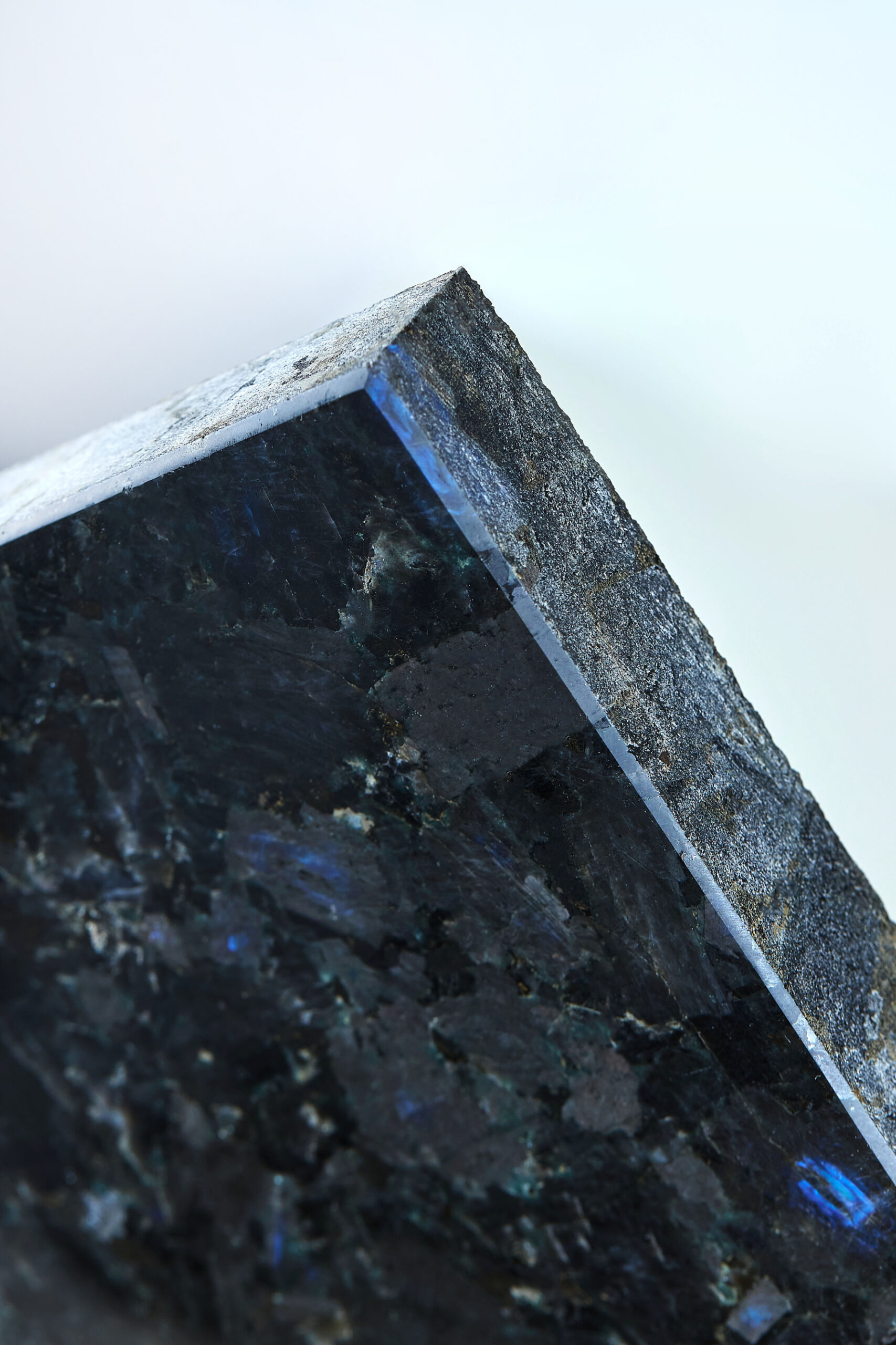 Close-up of labradorite texture with a dark crystalline surface and natural blue flashes